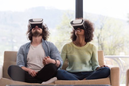 Téléchargez les photos : Couple multiethnique utilisant un casque de réalité virtuelle - en image libre de droit