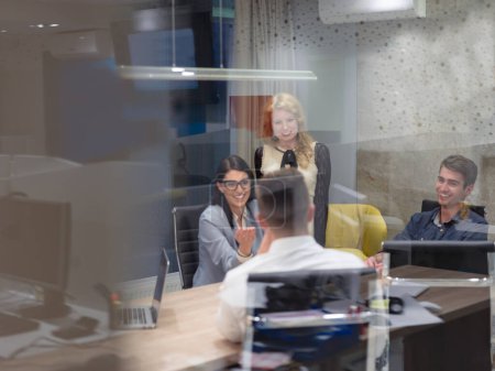 Téléchargez les photos : "Startup Business Team à une réunion dans un immeuble de bureaux de nuit moderne" - en image libre de droit