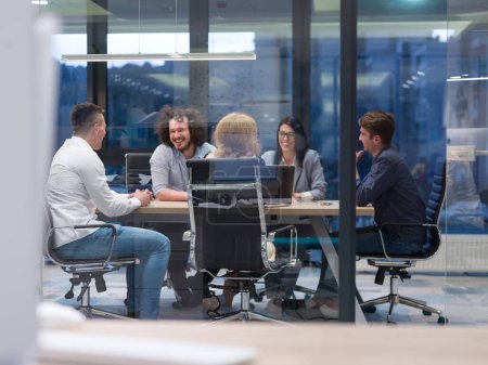 Foto de "Startup Business Team en una reunión en el moderno edificio de oficinas nocturnas" - Imagen libre de derechos