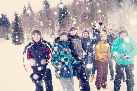 Téléchargez les photos : Groupe de jeunes jetant de la neige dans les airs - en image libre de droit