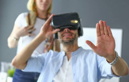 Téléchargez les photos : Jeune programmeur de logiciels masculins testant une nouvelle application avec des lunettes de réalité virtuelle 3d au bureau. - en image libre de droit