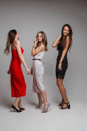 Téléchargez les photos : Laughing embracing women in cocktail dresses. - en image libre de droit
