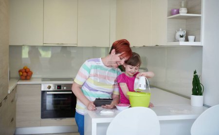 Foto de Madre e hija jugando y preparando masa en la cocina. - Imagen libre de derechos