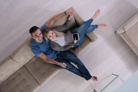 Téléchargez les photos : Jeune couple dans le salon avec tablette vue du dessus - en image libre de droit