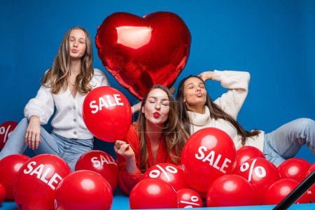 Foto de Hermosas chicas con la venta de globos de aire y globo del corazón. - Imagen libre de derechos