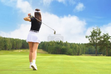 Téléchargez les photos : Femme golfeur frappe un fairway tourné vers le club house. - en image libre de droit