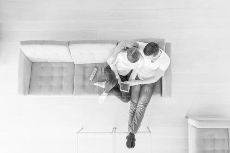 Téléchargez les photos : Jeune couple dans le salon en utilisant tablette vue du dessus - en image libre de droit