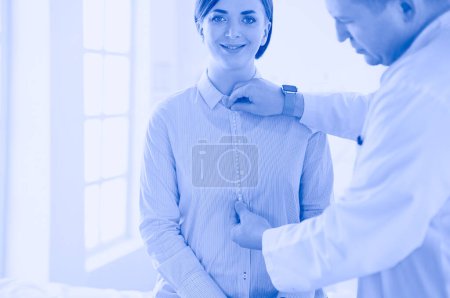 Photo for Doctor showing young patient her chest in his office at the hospital - Royalty Free Image