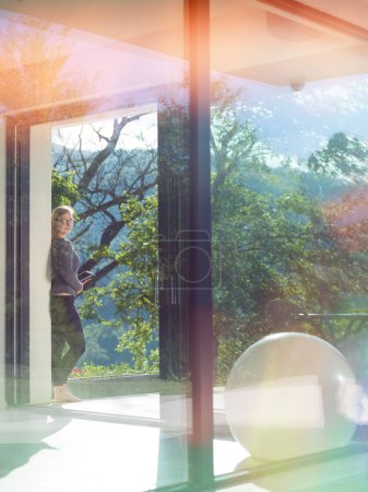 Foto de Mujer usando tableta frente a villa de lujo en casa - Imagen libre de derechos