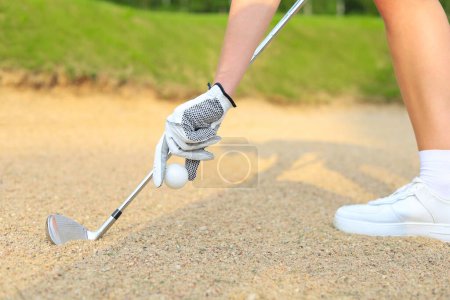 Téléchargez les photos : Main mettant la balle de golf sur le tee dans le terrain de golf. - en image libre de droit