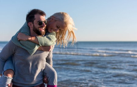 Téléchargez les photos : Couple s'amuser à la plage pendant l'automne - en image libre de droit