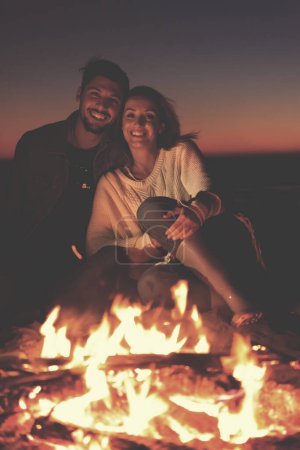 Foto de Retrato de pareja joven disfrutando por la noche en la playa - Imagen libre de derechos