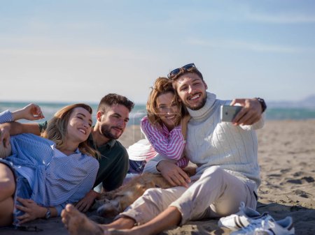 Foto de Grupo de amigos divirtiéndose en la playa durante el día de otoño - Imagen libre de derechos