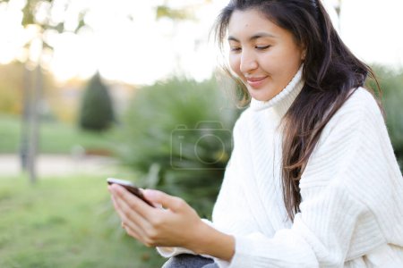 Foto de Céntrate en la chica japonesa manteniendo el teléfono inteligente y sonriendo. - Imagen libre de derechos