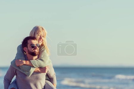 Téléchargez les photos : Couple s'amuser à la plage pendant l'automne - en image libre de droit