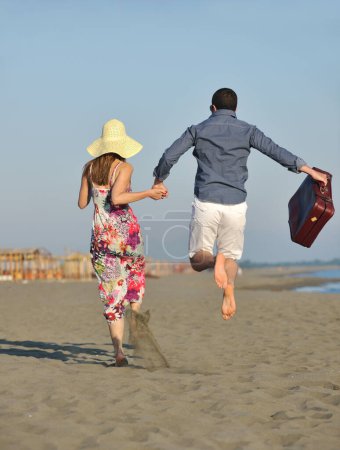 Foto de Pareja en la playa con bolsa de viaje - Imagen libre de derechos