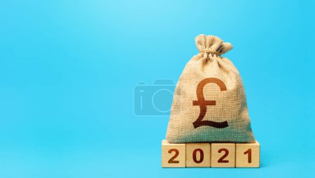 Photo for British pound sterling money bag and blocks 2021. Budget planning for next year. Beginning of new decade. Business plans and development prospects. Revenues expenses, investment and financing. - Royalty Free Image