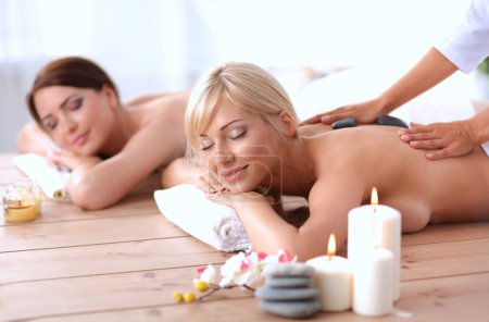 Foto de Dos mujeres hermosas jóvenes relajándose y disfrutando en el centro de spa - Imagen libre de derechos