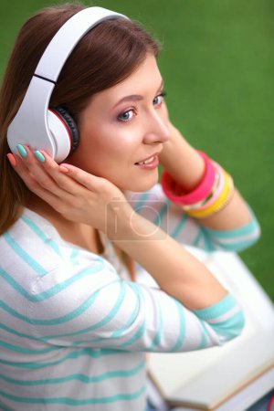 Téléchargez les photos : Femme écoutant la musique assise sur l'herbe - en image libre de droit