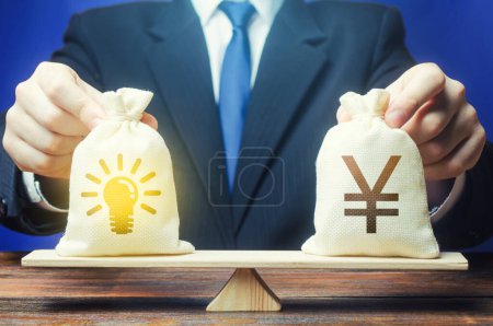 Photo for Yen or Yuan money bag and ideas patents. Buying a startup. Invest in promising companies, technologies. Stimulating development of innovative business, scientific progress. Grants. Brain drain. - Royalty Free Image