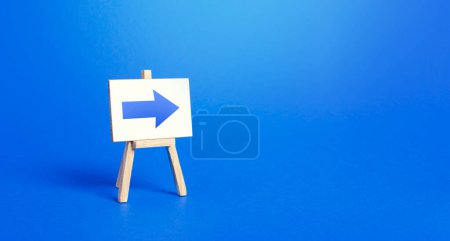 Photo for Easel with a blue right arrow. Sign of direction. Advertising of the location of a store or outlet. Minimalism. Distracting maneuver. Restriction of movement, change of course. Short road. - Royalty Free Image