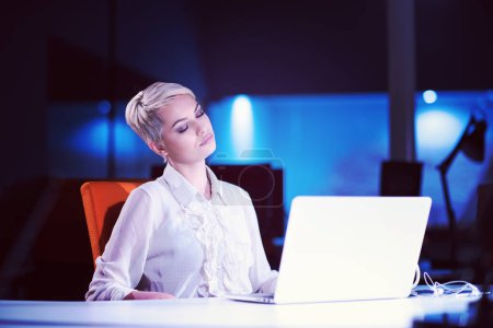 Téléchargez les photos : Femme travaillant sur ordinateur portable dans le bureau de démarrage de nuit - en image libre de droit