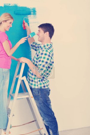 Photo for Young couple painting wall at new home - Royalty Free Image