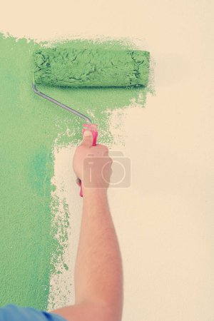 Foto de Guapo joven pintar pared blanca en color - Imagen libre de derechos