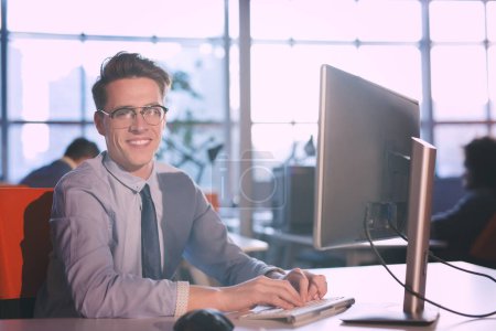 Téléchargez les photos : "homme d'affaires travaillant à l'aide d'un ordinateur au bureau de démarrage
" - en image libre de droit