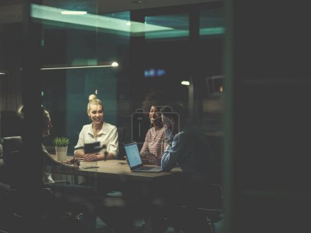 Foto de Equipo de negocios de startups multiétnicas en oficina nocturna - Imagen libre de derechos