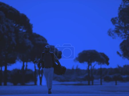 Téléchargez les photos : Joueur de golf marchant et portant sac - en image libre de droit