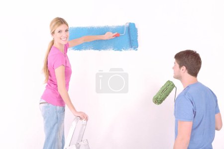 Foto de Joven pareja pintura pared en nuevo hogar - Imagen libre de derechos