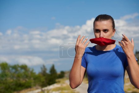 Foto de Mujer con máscara protectora relajante después de correr - Imagen libre de derechos