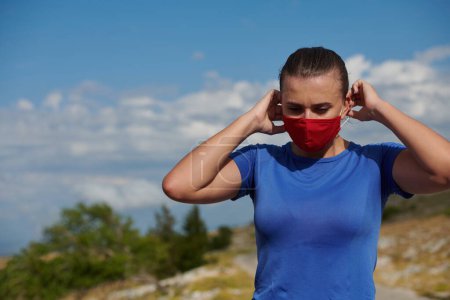 Téléchargez les photos : Femme avec masque de protection relaxant après la course - en image libre de droit
