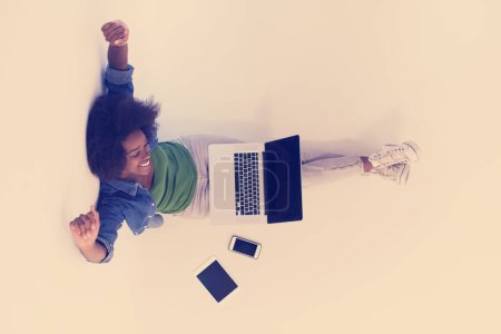 Photo for "african american woman sitting on floor with laptop top view" - Royalty Free Image