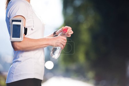 Téléchargez les photos : Femme boire de l'eau après le jogging - en image libre de droit