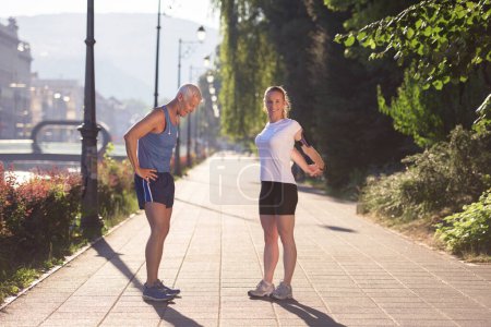 Photo for Couple warming up and stretching before jogging - Royalty Free Image