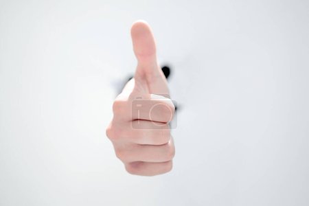 Photo for Businessman breaking through the paper wall and showing thumb up - Royalty Free Image