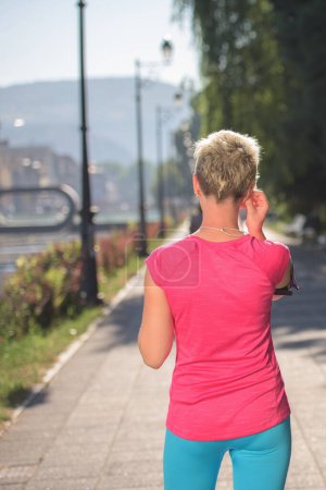 Photo for Jogging woman setting phone before jogging - Royalty Free Image