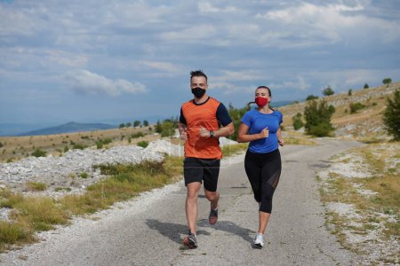 Photo for Couple running in nature wearing mask - Royalty Free Image