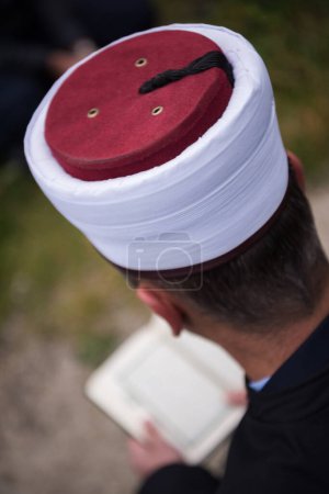 Téléchargez les photos : Livre sacré de Coran lu par imam sur les funérailles islamiques - en image libre de droit