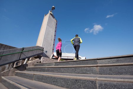 Téléchargez les photos : Jeune couple jogging sur les marches - en image libre de droit