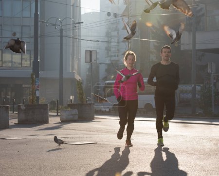 Téléchargez les photos : Jeune couple jogging dans la ville - en image libre de droit