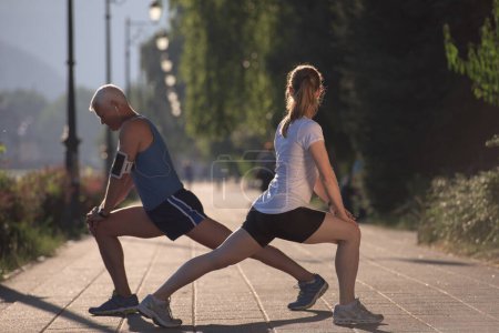 Téléchargez les photos : Couple échauffement et étirement avant le jogging - en image libre de droit