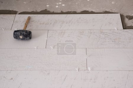 Foto de "Baldosas de efecto madera de cerámica y herramientas para el azulejo en el suelo" - Imagen libre de derechos