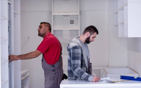 Téléchargez les photos : Travailleurs installant une nouvelle cuisine - en image libre de droit