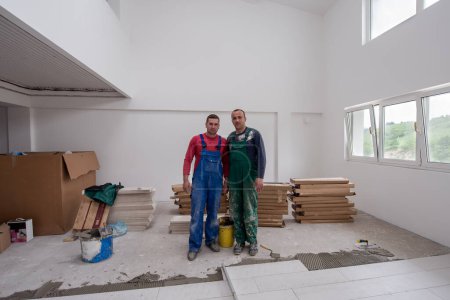 Téléchargez les photos : Portrait de Travailleurs et constructeurs avec uniforme sale dans l'appartement - en image libre de droit