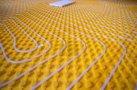 Foto de Instalación de calefacción por suelo radiante amarillo con tuberías blancas - Imagen libre de derechos