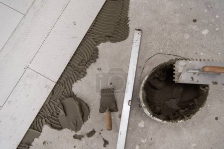 Foto de Baldosas de efecto madera de cerámica y herramientas para el azulejo en el suelo - Imagen libre de derechos