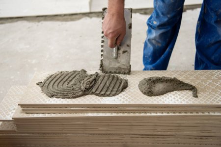 Foto de "trabajador que instala las baldosas de efecto madera cerámica en el suelo" - Imagen libre de derechos
